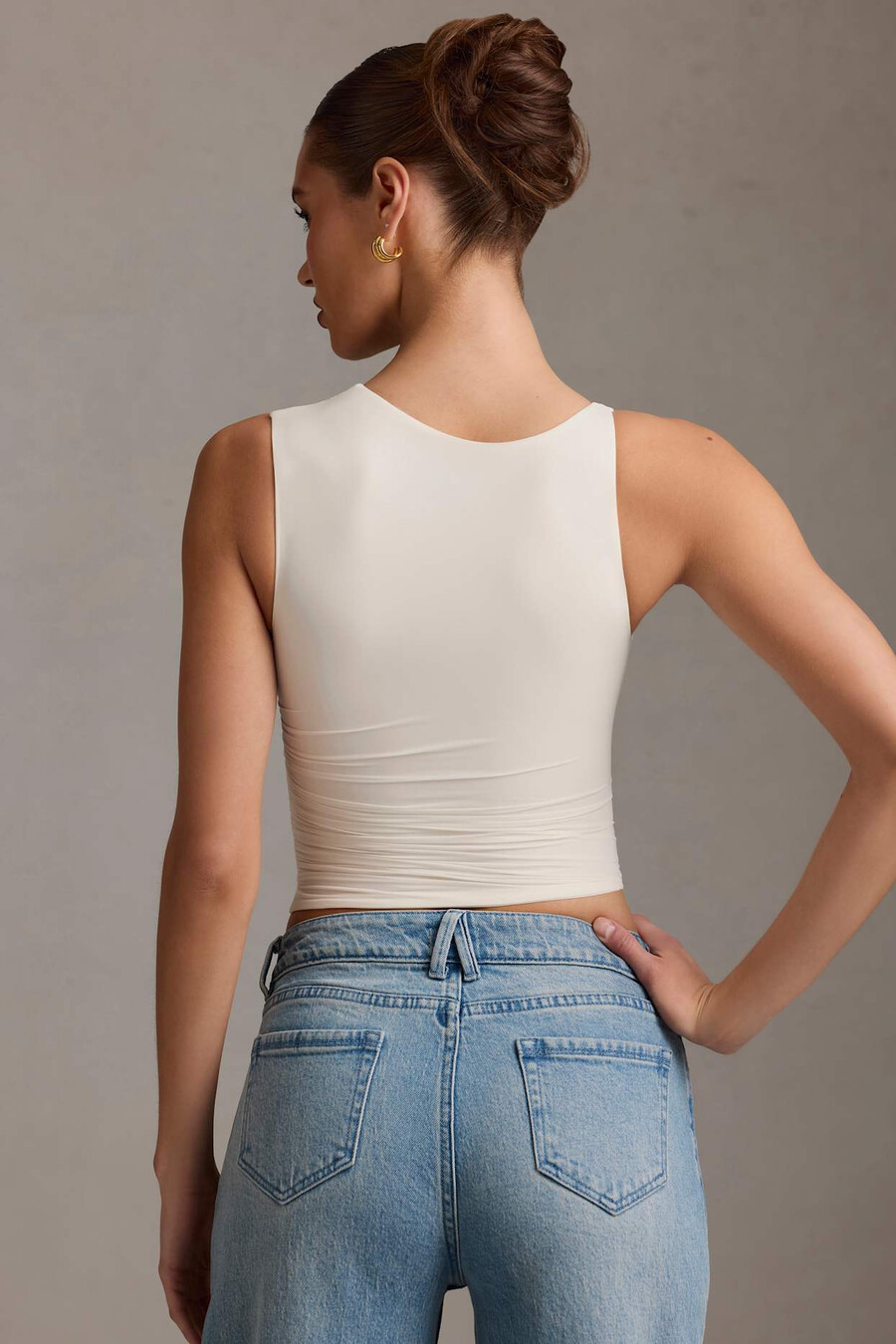 asymmetrische tanktop met plooien in vanillekleur.