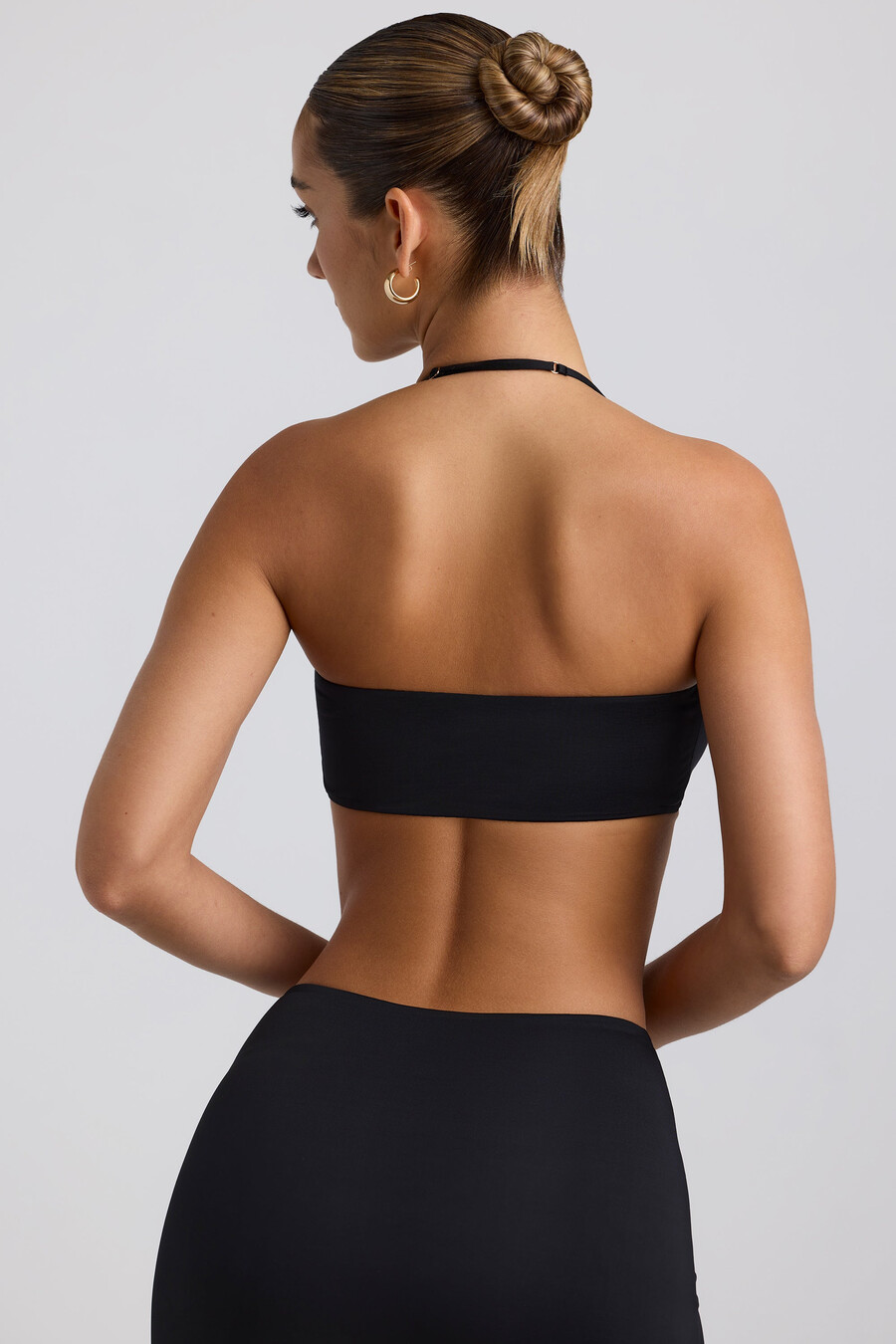 soepelvallende halterbralette van jersey met metalen details in zwart.