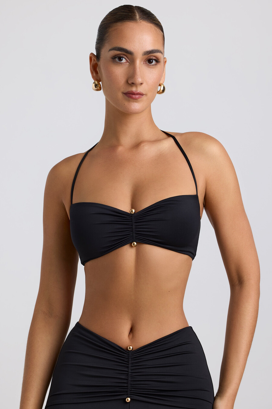 soepelvallende halterbralette van jersey met metalen details in zwart.