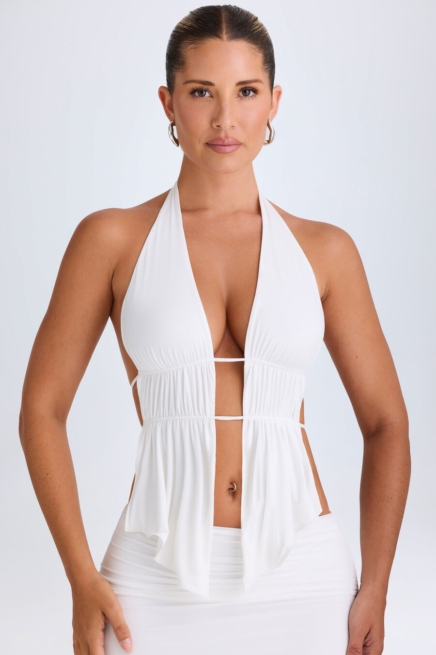 crop top met uitgesneden details en plooien in halternek in het wit.