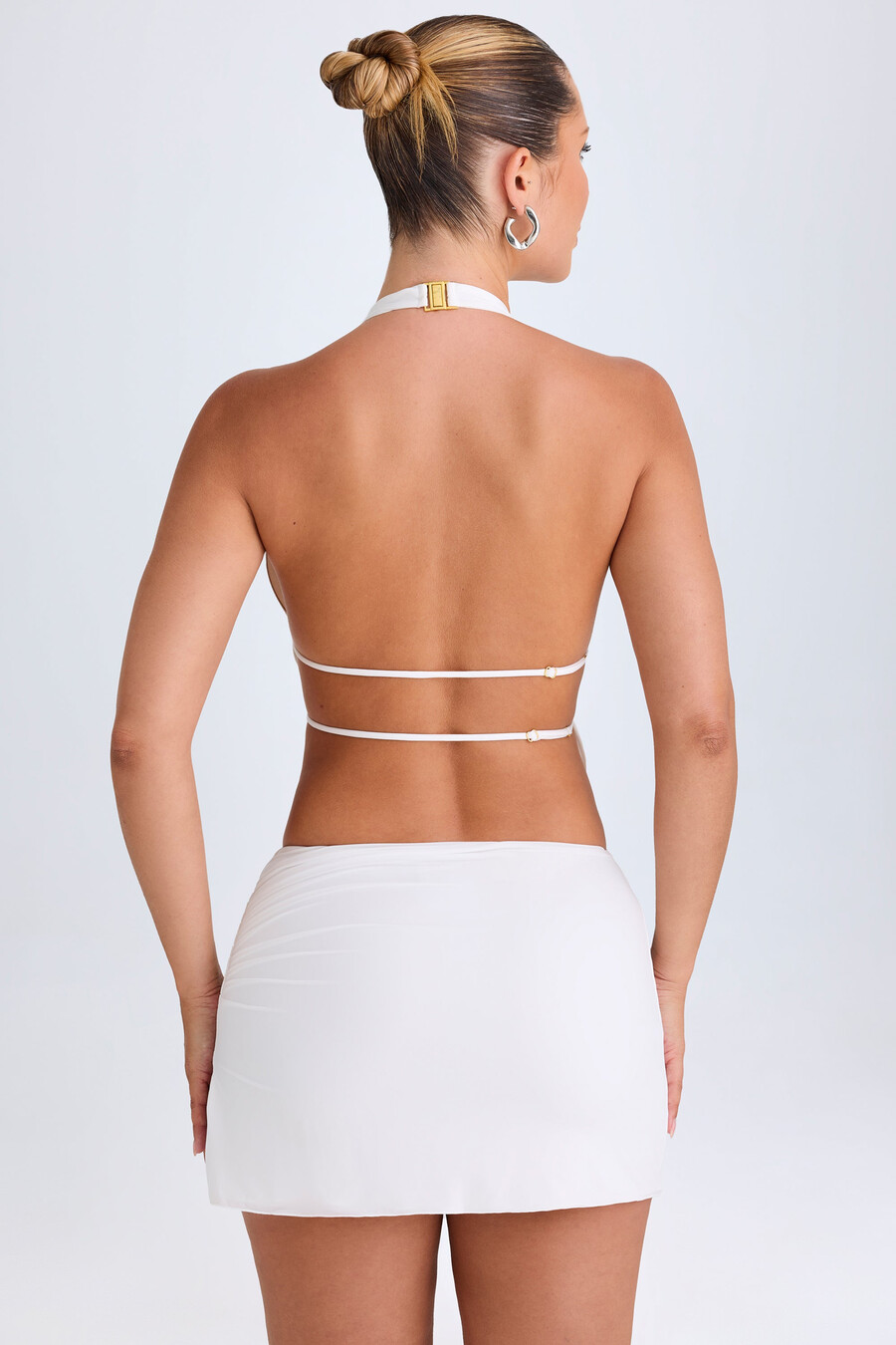 crop top met uitgesneden details en plooien in halternek in het wit.