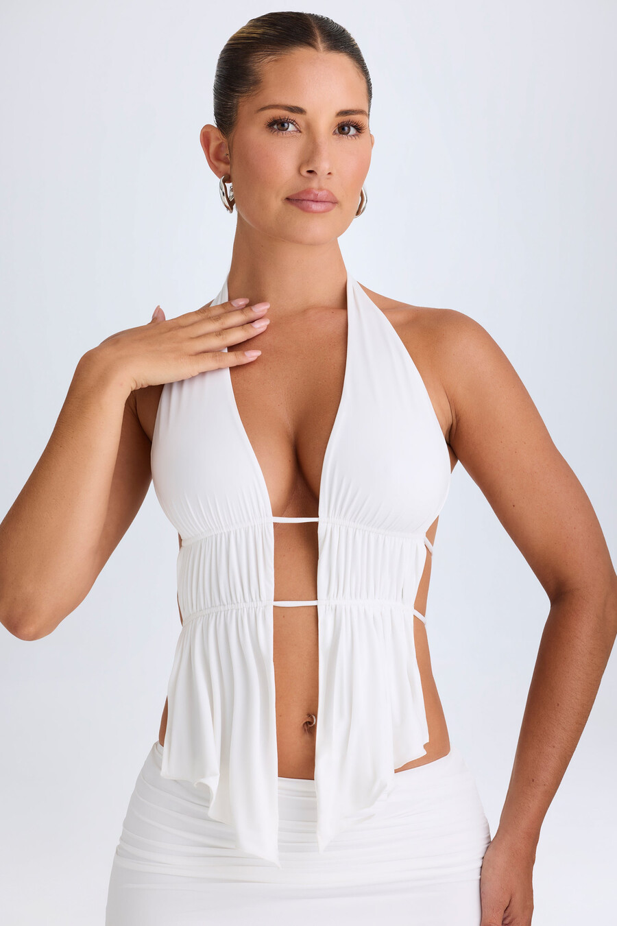 crop top met uitgesneden details en plooien in halternek in het wit.